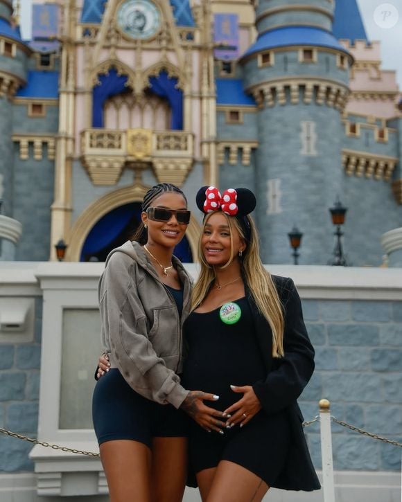 Com o castelo da Cinderela ao fundo, Brunna Gonçalves e Ludmilla posam abraçadas no parque Magic Kingdom; a dançarina exibe o barrigão da primeira filha do casal, Zuri