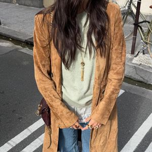 Bruna Marquezine apostou na calça combinada a um suéter verde-claro, sobretudo caramelo de camurça e acessórios dourados.