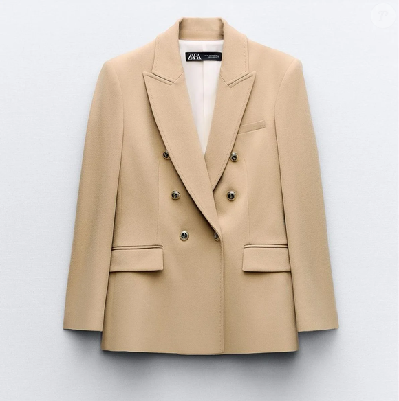 Em nossas buscas fashion, encontramos no Enjoei um modelo semelhante da Zara: blazer bege alongado, justo, cruzado com botões dourados, por R$ 380 na plataforma de desapego