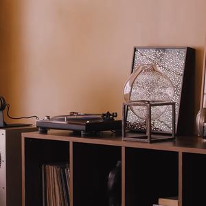 Na sala de estar do apartamento, Manu Gavassi e Jullio Reis apostaram em uma decoração que reúne móveis de design, peças garimpadas e objetos de diferentes estilos. Entre os destaques está um sofá de veludo amarelo apoiado sobre esferas pretas, elemento que combina características escultóricas e funcionais