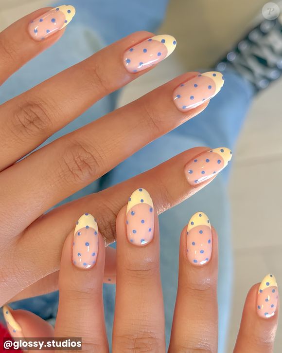 Unhas 2026: Base em amarelo manteiga com poás azul bebê - dois tons queridinhos da temporada que juntos criam um visual delicado, leve e elegante.