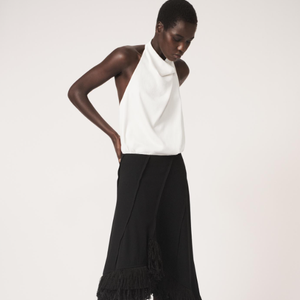 Saia preta da Zara Brasil tem comprimento midi, deixando o visual ainda mais sofisticado. Por apenas R$ 439,00, tem cintura média, franjas e barra assimétrica.