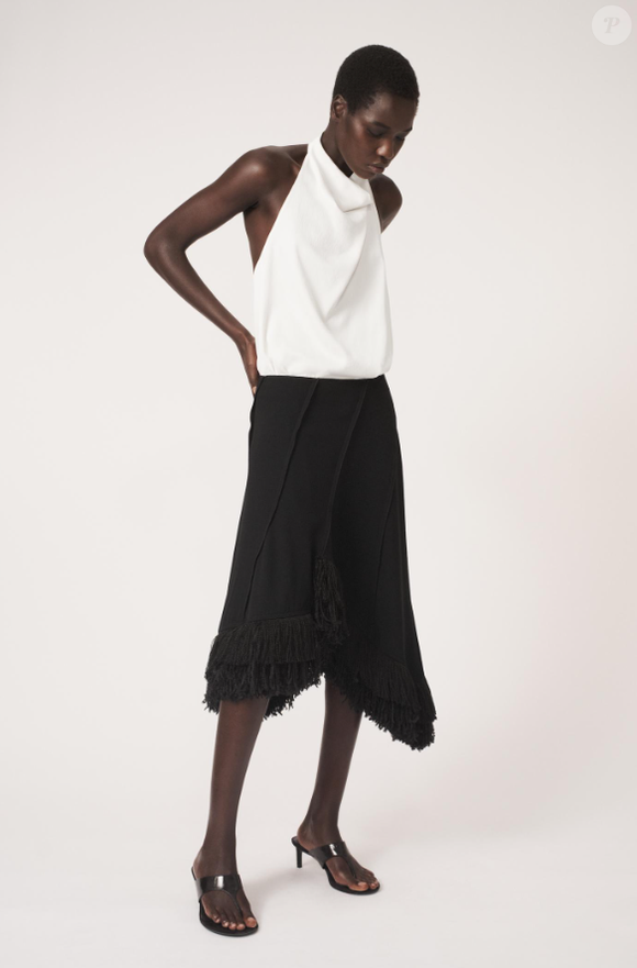 Saia preta da Zara Brasil tem comprimento midi, deixando o visual ainda mais sofisticado. Por apenas R$ 439,00, tem cintura média, franjas e barra assimétrica.