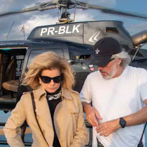 Na cena em que Odete Roitman desce do helicóptero no Brasil, é possível observar que ela usa uma roupa preta, trentch coat e bolsa de grife.