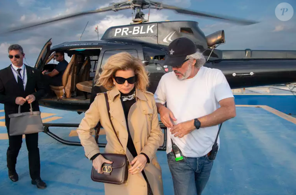 Na cena em que Odete Roitman desce do helicóptero no Brasil, é possível observar que ela usa uma roupa preta, trentch coat e bolsa de grife.