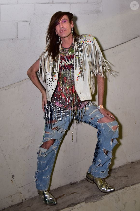 Dudu Bertholini exalou autenticidade com jaqueta branca de franjas e aplicações metálicas em estética glam rock. A sobreposição contou com blusa repleta de paetês, correntes e miçangas sobre jeans oversized com rasgos e grafismos