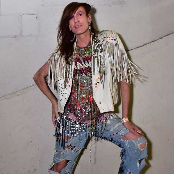 Dudu Bertholini exalou autenticidade com jaqueta branca de franjas e aplicações metálicas em estética glam rock. A sobreposição contou com blusa repleta de paetês, correntes e miçangas sobre jeans oversized com rasgos e grafismos