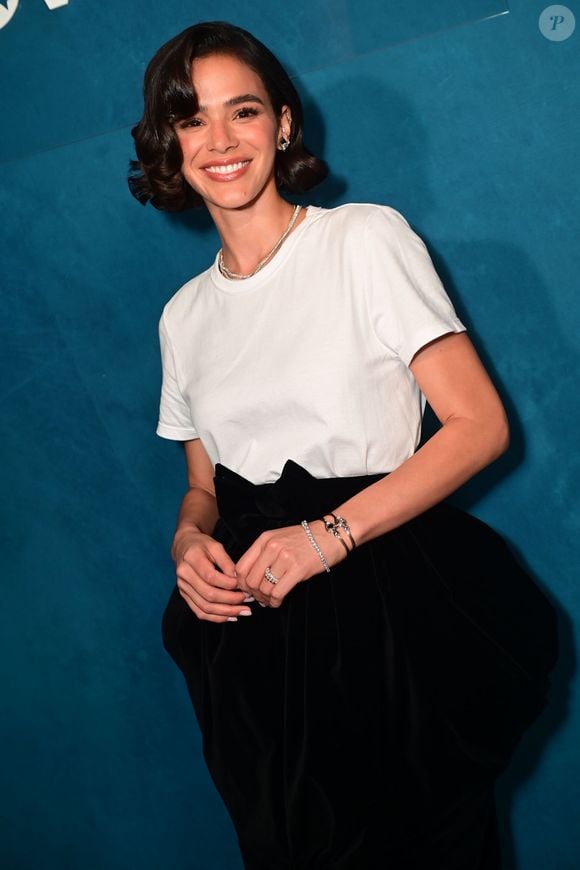 Bruna Marquezine aposta em saia de veludo preto com volume nos quadris e grande laço na cintura, criando uma produção dramática e sofisticada