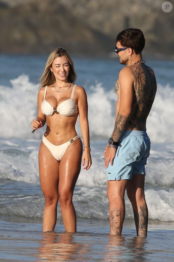 MC Gui curte praia com a namorada, que apostou em biquíni branco estiloso