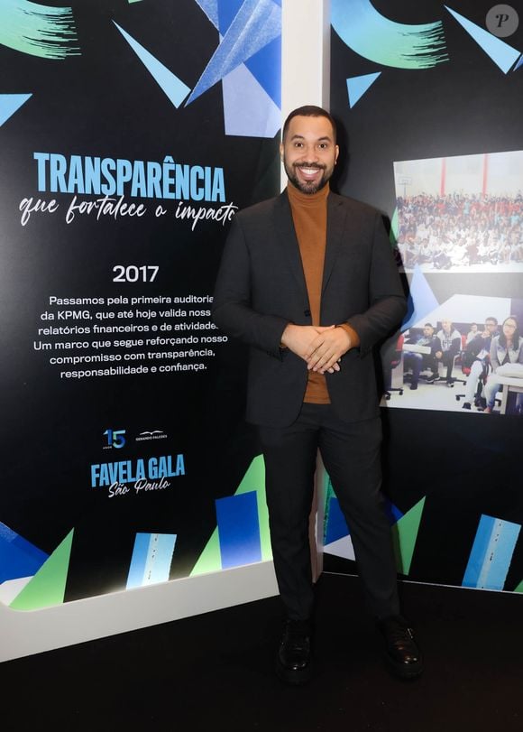 Gil do Vigor: sua produção aposta na sobreposição elegante de terno preto clássico com blusa de gola alta em tom marrom-terroso. O visual alinha o formal ao moderno, arrematado por sapatos sociais pretos de solado tratorado