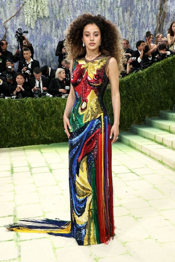 QUE LINDO! Chase Infiniti chega ao Met Gala 2026 de Thom Browne com um vestido longo totalmente bordado, como se fosse tinta em cores vibrantes formando um corpo feminino