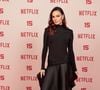 Isis Valverde: veste um modelo longo preto minimalista de mangas compridas e gola alta, com detalhe drapeado ajustado no quadril e saia fluida assimétrica, além de escarpim preto de salto alto