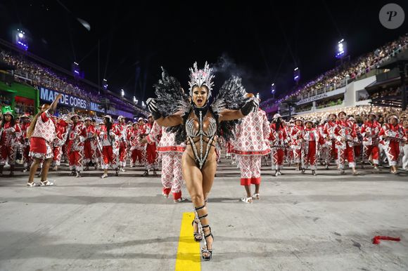 Viviane Araújo comemorou seu 18º ano em frente à bateria do Salgueiro em 2025 com uma fantasia prateada e preta com uma coroa de águia