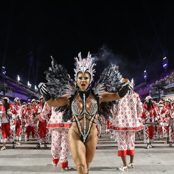 Viviane Araújo comemorou seu 18º ano em frente à bateria do Salgueiro em 2025 com uma fantasia prateada e preta com uma coroa de águia