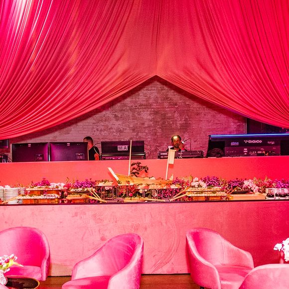 A cenografia da festa da WePink combina lounges de veludo, flores, mesas espelhadas e iluminação em tons de rosa