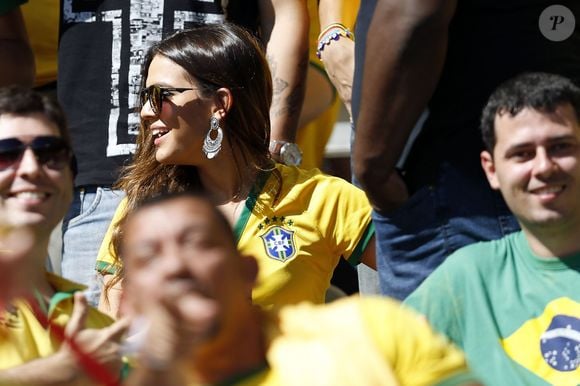 Brasilcore com toque boho chic? Bruna Marquezine já apostou na camisa da seleção combinada com calça jeans azul, óculos de sol e brincos que remetem à estética boêmia. O visual é uma ótima inspiração para quem quer torcer com estilo na Copa do Mundo de 2026
