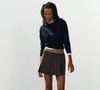 O short marrom de cintura alta da Zara aposta em pregas e botões frontais para deixar a produção mais sofisticada, enquanto a modelagem ajuda a valorizar e alongar visualmente as pernas