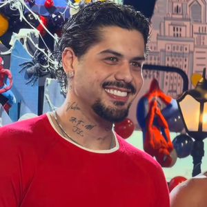 Zé Felipe usou uma blusa vermelha de manga longa e ajustada ao corpo, combinada com calça jeans clara de corte reto e sapatos escuros