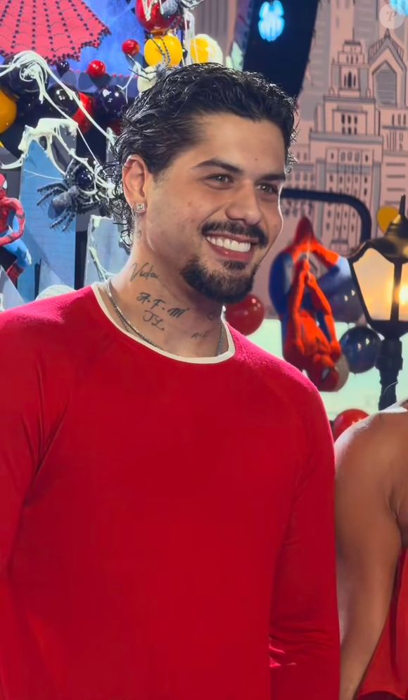 Zé Felipe usou uma blusa vermelha de manga longa e ajustada ao corpo, combinada com calça jeans clara de corte reto e sapatos escuros