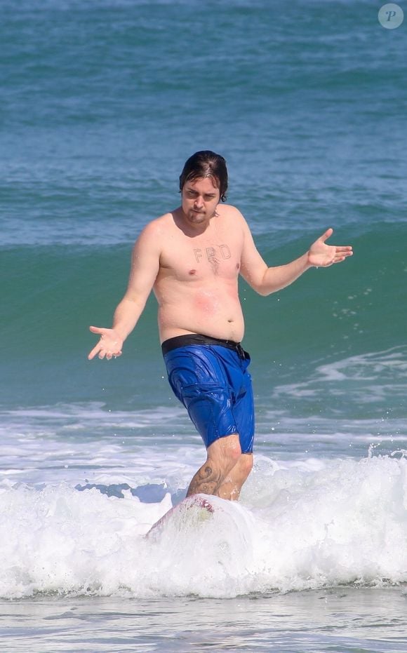 Sem camisa e usando apenas uma bermuda azul, Felipe Dylon mostrou seu físico ao curtir um dia de surfe em Ipanema, no RJ