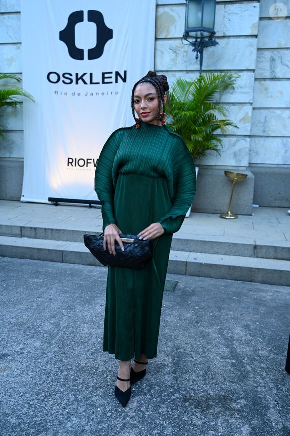 Any Gabrielly: com uma presença escultural, Any Gabrielly deslumbrou em um design da Osklen que explora texturas e volumes arquitetônicos. O vestido longo em tom verde-esmeralda profundo é confeccionado em um plissado rígido que cria um efeito de casulo nos braços e ombros, conferindo uma silhueta dramática e poderosa