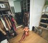 Ex-mulher de Kanye West, Kim Kardashian surgiu apenas com a parte de cima, sentada no clost, com as roupas em volta.