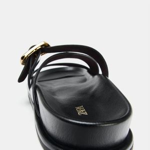 A tendência das sandálias japonesas chegou à Zara com uma proposta minimalista: modelo plano, bico redondo, tiras e fivelas na parte frontal por R$ 279,00