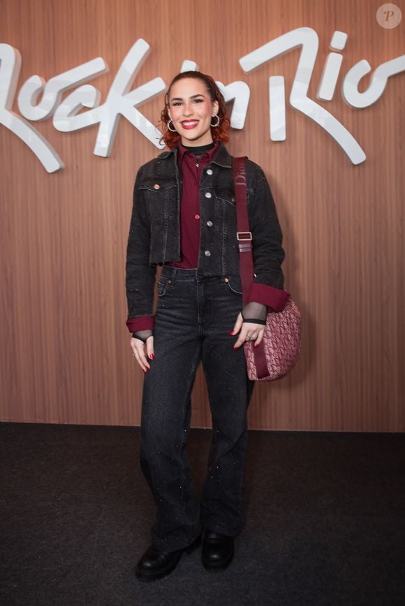Filha de Renato Aragão, Lívian Aragão apostou em um look all black com jaqueta cropped, camisa vinho e bolsa estampada