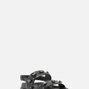 Nos pés, a escolha foi uma papete preta em couro com pedrarias e fivela, da Arezzo, avaliada em R$ 599,90