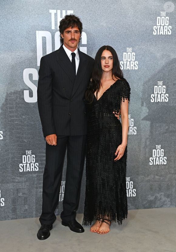 Para a première de "Ponto Sem Retorno", Margaret Qualley, ao lado de Jacob Elordi, combinou um vestido preto decotado com franjas, cabelos escuros soltos e uma das propostas mais inusitadas da coleção Cruise 2027 da Chanel