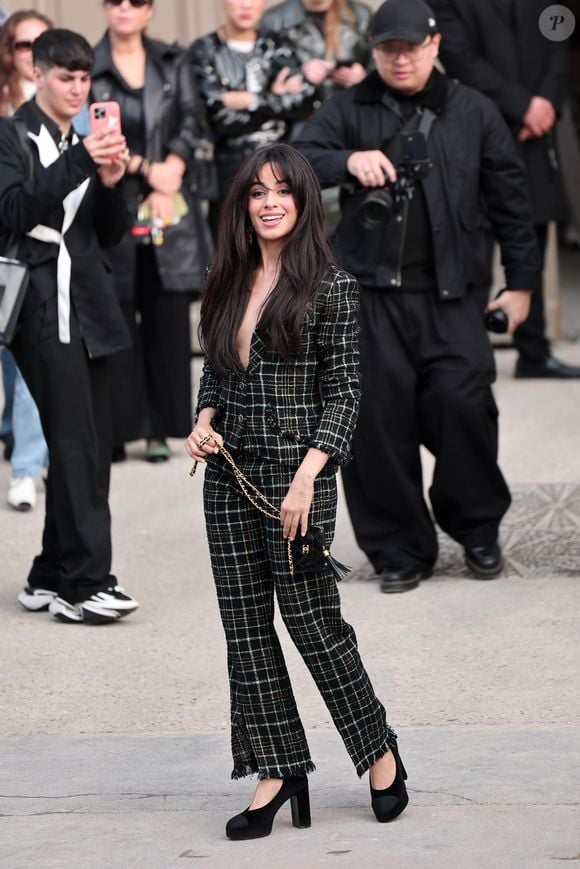 Camila Cabello em look xadrez preto e salto durante a Semana de Moda de Paris 2025.