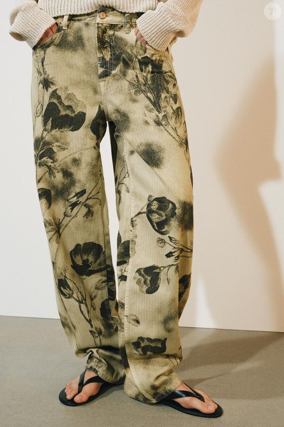 Para quem gosta de jeans que fogem do tradicional, a calça estampada da Zara é uma opção para explorar a tendência vintage. O modelo custa R$ 439,00 e pode ser usado com os tênis On Running Cloud 6 na cor bordô, criando uma combinação que mistura referências retrô e esportivas
