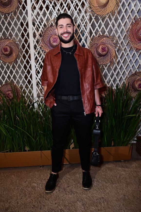 Marcelo optou por uma composição urbana ao sobrepor uma jaqueta de couro marrom de mangas curtas a uma camiseta preta básica e calça skinny de alfaiataria na mesma cor. O jornalista finalizou a produção com sapatos sociais pretos, colar de corrente discreto e uma bolsa tiracolo com alça grossa