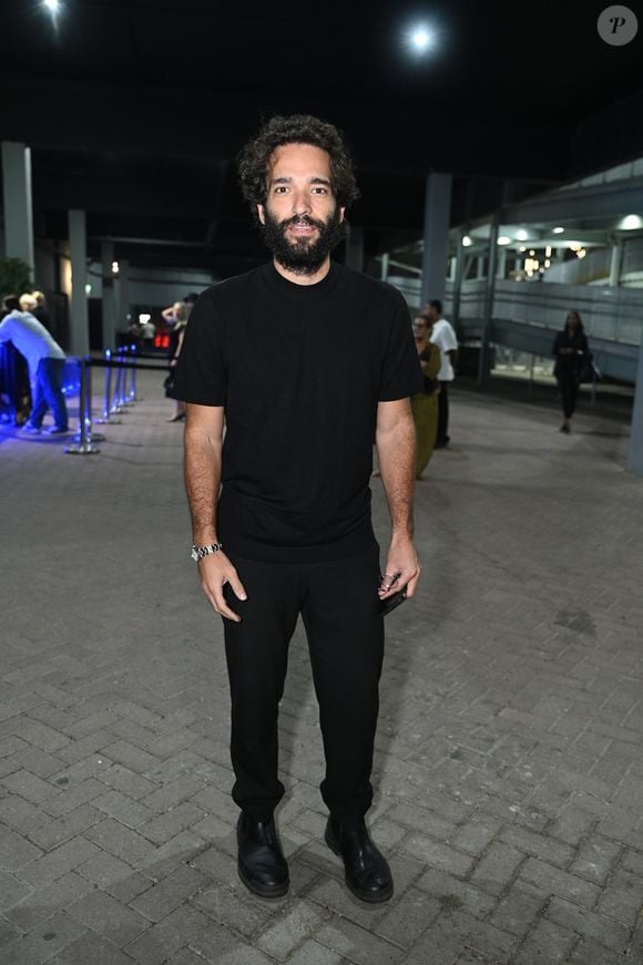 Humberto Carrão apostou em um visual monocromático preto de estética minimalista e urbana. O ator vestiu uma camiseta preta de gola careca levemente ajustada combinada com calça de sarja no mesmo tom e caimento reto. Para arrematar a produção sóbria, ele optou por botas de couro pretas de bico arredondado e um relógio de pulso prateado com pulseira metálica