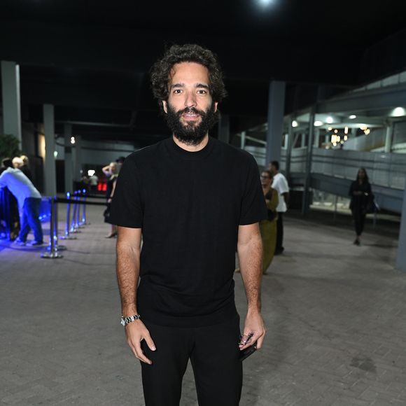 Humberto Carrão apostou em um visual monocromático preto de estética minimalista e urbana. O ator vestiu uma camiseta preta de gola careca levemente ajustada combinada com calça de sarja no mesmo tom e caimento reto. Para arrematar a produção sóbria, ele optou por botas de couro pretas de bico arredondado e um relógio de pulso prateado com pulseira metálica
