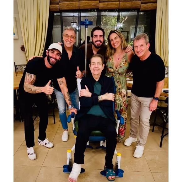 Faustão surgiu em foto com pé imobilizado ao lado da mulher, Luciana Cardoso, do filho do meio, João Guilherme, de Gusttavo Lima, e empresários