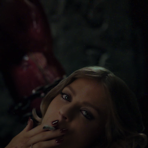 Luísa Sonza também fuma um cigarro enquanto é segurada pelo demônio