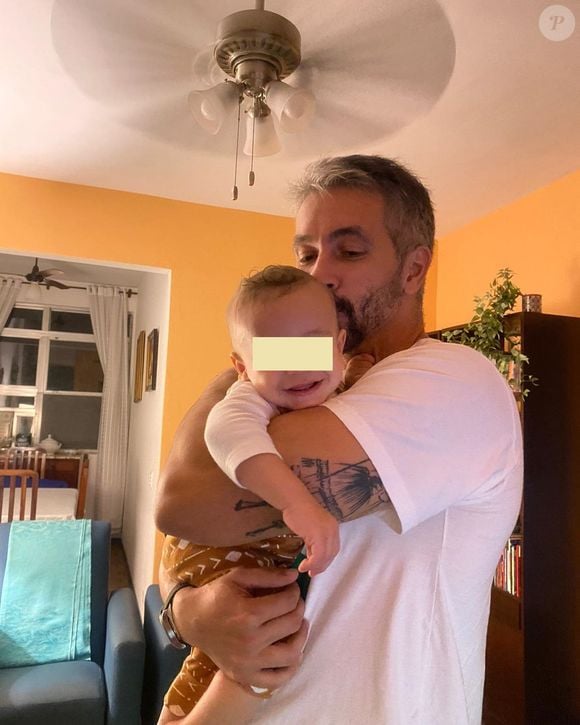 Danilo Vieira, repórter da Globo, dá colo ao filho hoje com 3 anos em foto de março de 2024