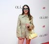 Valentina Herszage optou por um conjunto monocromático em tom de verde-oliva pastel. O look é composto por uma jaqueta de sarja com botões frontais forrados e gola pontuda, acompanhada de shorts de cintura alta no mesmo tecido e cor. Para quebrar a paleta neutra, Valentina escolheu uma bolsa de mão amarela vibrante com design estruturado