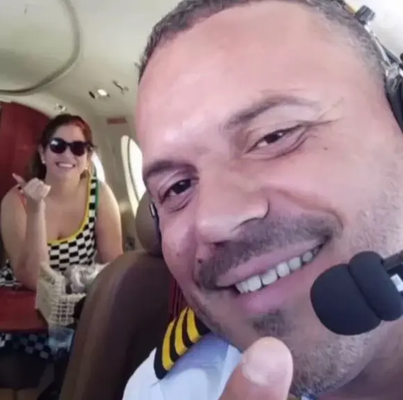 Marília Mendonça posa sorridente com o copiloto Tarciso Pessoa Viana, uma das vítimas, em uma selfie. O registro foi feito antes da decolagem