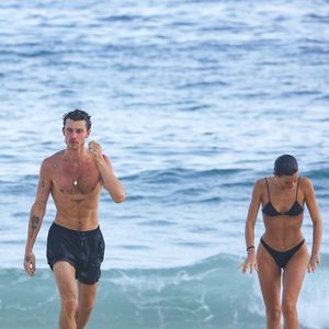 Atriz e cantor são fotografados em clima de romance enquanto caminham pela areia