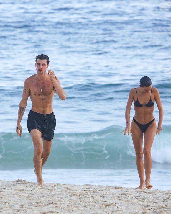 Atriz e cantor são fotografados em clima de romance enquanto caminham pela areia