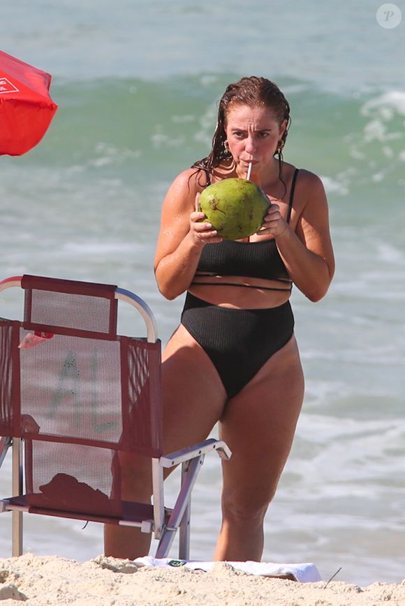 De maiô, Paolla Oliveira matou a sede com água de coco
