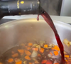 A seguir, acrescente meia garrafa de vinho tinto seco e deixe reduzir até criar consistência de molho