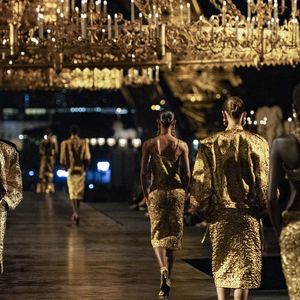 O dourado também ganhou destaque na Semana de Moda de Paris, onde a Yves Saint-Laurent apresentou sua coleção Primavera-Verão 2027 na Esplanada do Trocadero. Além dos looks brilhantes, a passarela teve dois gigantescos lustres de estilo renascentista e as luzes da Torre Eiffel ao fundo, reforçando a proposta de luxo explícito e maximalista