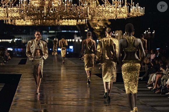 O dourado também ganhou destaque na Semana de Moda de Paris, onde a Yves Saint-Laurent apresentou sua coleção Primavera-Verão 2027 na Esplanada do Trocadero. Além dos looks brilhantes, a passarela teve dois gigantescos lustres de estilo renascentista e as luzes da Torre Eiffel ao fundo, reforçando a proposta de luxo explícito e maximalista