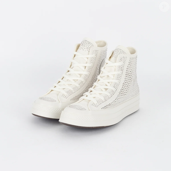 Além dos cristais prateados, o Converse Chuck 70 Hi 'Swarovski White' mantém detalhes de inspiração vintage, como a entressola e a biqueira envernizadas, enquanto a palmilha OrthoLite é destacada pela proposta de conforto