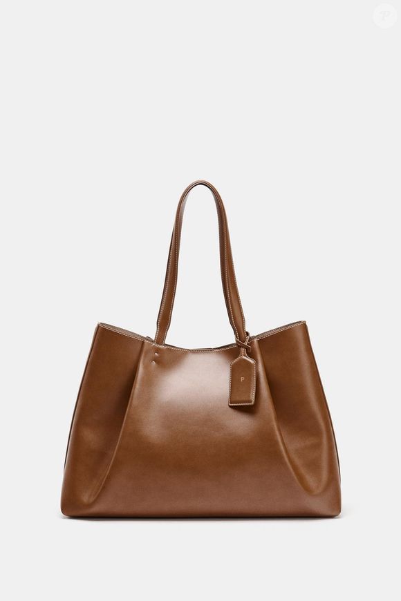 O toque diferente de cor, sem abandonar totalmente a paleta de azuis,  fica por conta desta bolsa também da fast fashion Zara, em um lindo marrom glacê. Um design com silhueta estilo tote bag, com grande capacidade, que passa a energia de quiet luxury, e que dá ao look um toque marcante graças às tachas, por R$ 279,00