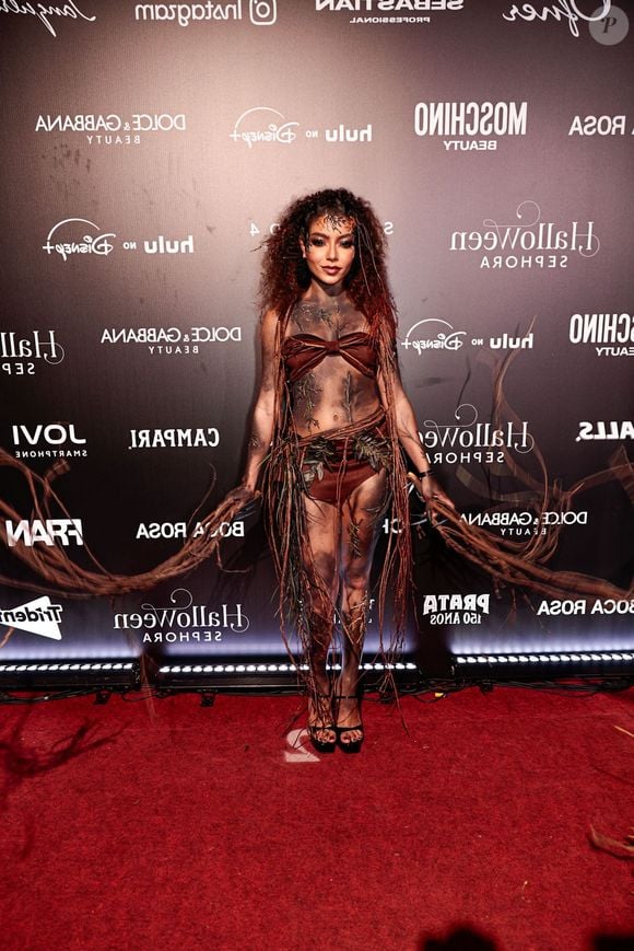 Any Gabrielly, de 'Habeas Corpus', da Netflix: o visual evoca elementos da natureza e raízes, destacando um conjunto de duas peças em tom marrom estruturado com amarrações. O corpo e os membros recebem pintura corporal artística simulando galhos, terra e folhagens secas acopladas