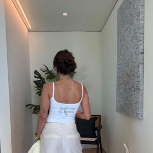 Em clima de Copa do Mundo, Anitta apostou em um visual casual e cheio de referências ao Brasil. A cantora surgiu com uma regata branca adornada por uma bandeira brasileira em strass, combinada com uma jorts em tom off-white e acessórios inspirados no futebol durante os ensaios para a aguardada cerimônia de abertura do Mundial de 2026